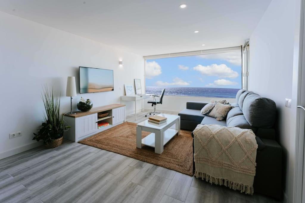 uma sala de estar com um sofá e uma grande janela em Apartamento balcón del Mar em Almeria