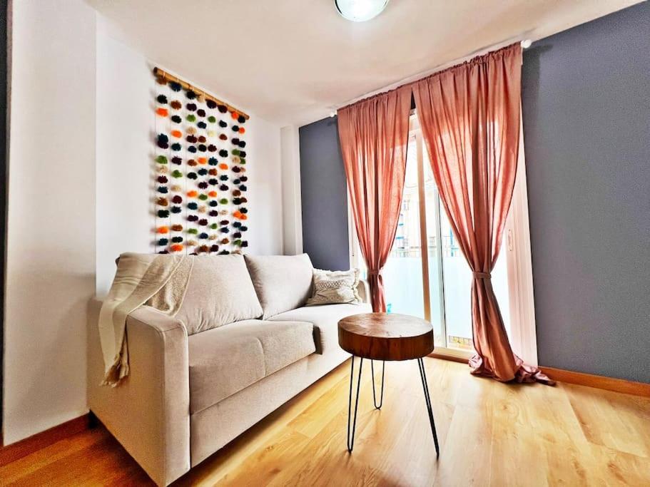 een woonkamer met een bank en een raam bij Céntrico y nuevo apartamento in Fuengirola