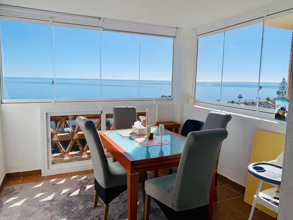 - une salle à manger avec une table et des chaises et une vue sur l'océan dans l'établissement Seaview Penthouse Magnificó Ático Duplex con vistas al mar, à Manilva