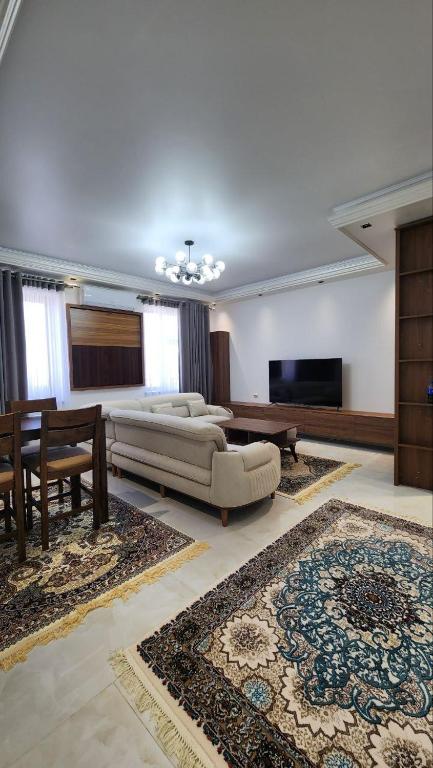 een grote woonkamer met een bank en een tafel bij APARTMENT SILVER HOUSE in Samarkand
