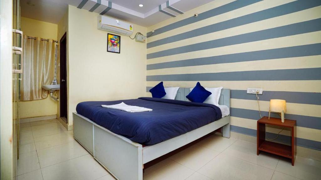 1 dormitorio con 1 cama con rayas azules y blancas en HIVEE-1 Rooms & Living Twin Bed AC, en Hyderabad