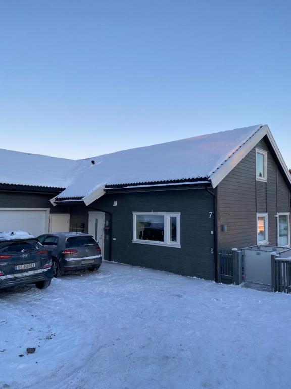 una casa con un techo cubierto de nieve encima en Hus i landlige omgivelser nær Granåsen skianlegg en Trondheim