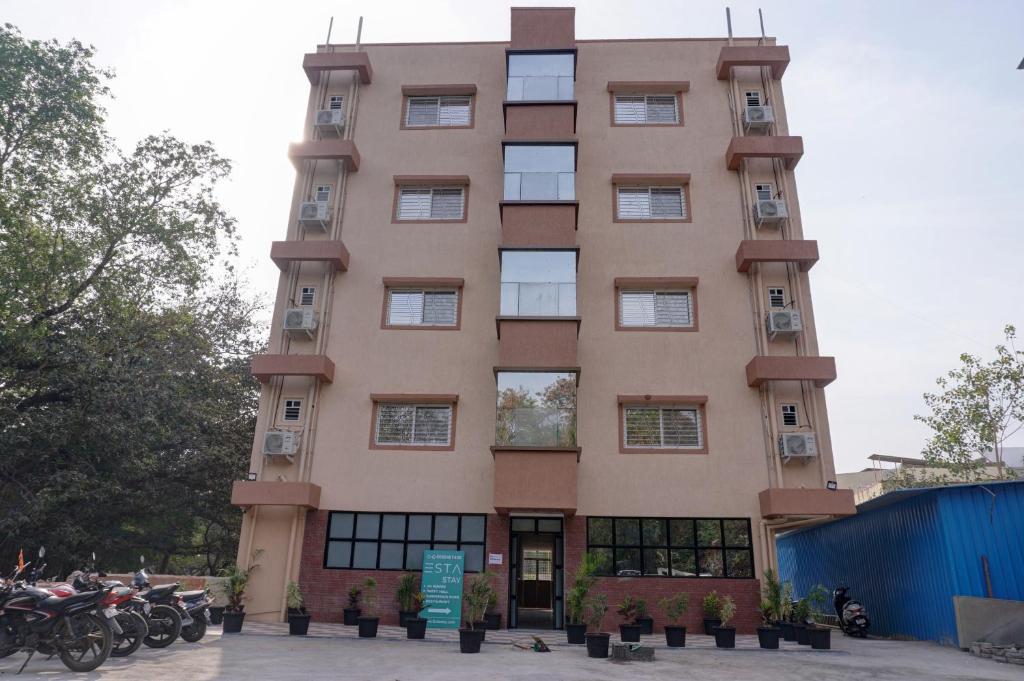 a tall building with motorcycles parked in front of it at ESTA STAY in Pune