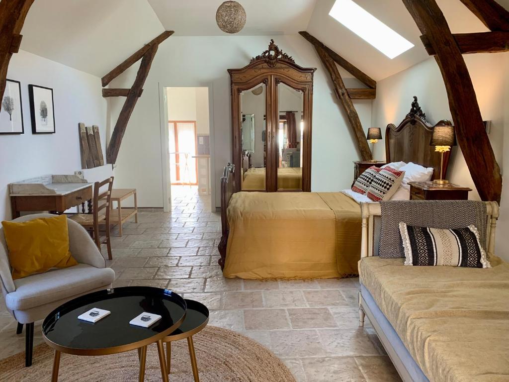 a bedroom with a bed and a couch and a table at L'appartement du Pont de Cause in Saint-Cybranet