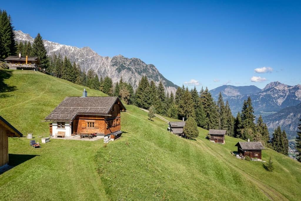 una casa en una colina con montañas en el fondo en Berghaus Kessler, en Vandans