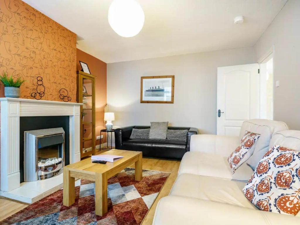 sala de estar con sofá blanco y chimenea en Pass the Keys Lovely Home in Holywood Lots Nearby Seaside, en Holywood