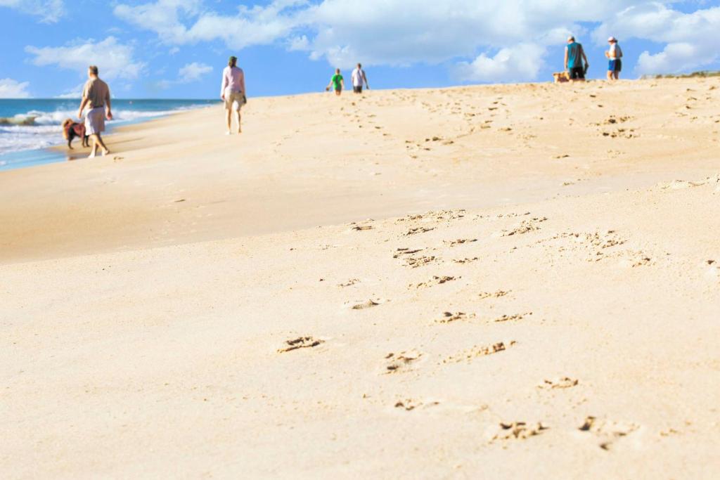 a group of people walking on the beach at Hyatt Place Dewey Beach in Dewey Beach