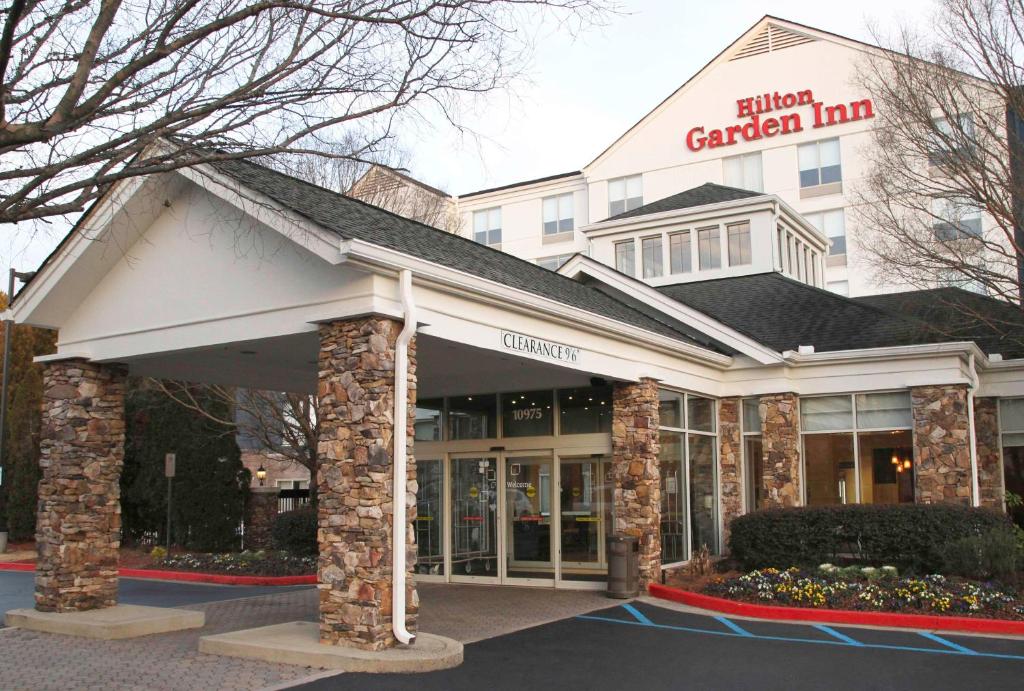 - Vistas frontales al edificio de una posada con jardín en Hilton Garden Inn Atlanta Northpoint en Alpharetta