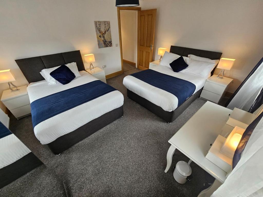 Habitación de hotel con 2 camas y mesa en Holiday in The Heart of Kerry, en Castlemaine