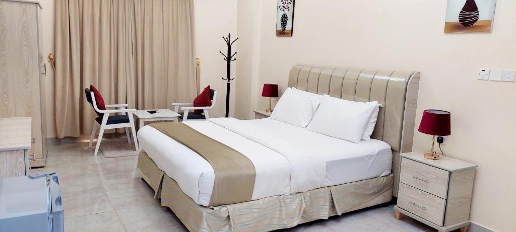 a bedroom with a bed and a table and chairs at Pearl Hotel Apartment - اللؤلؤ للشقق الفندقية in Al Buraymī