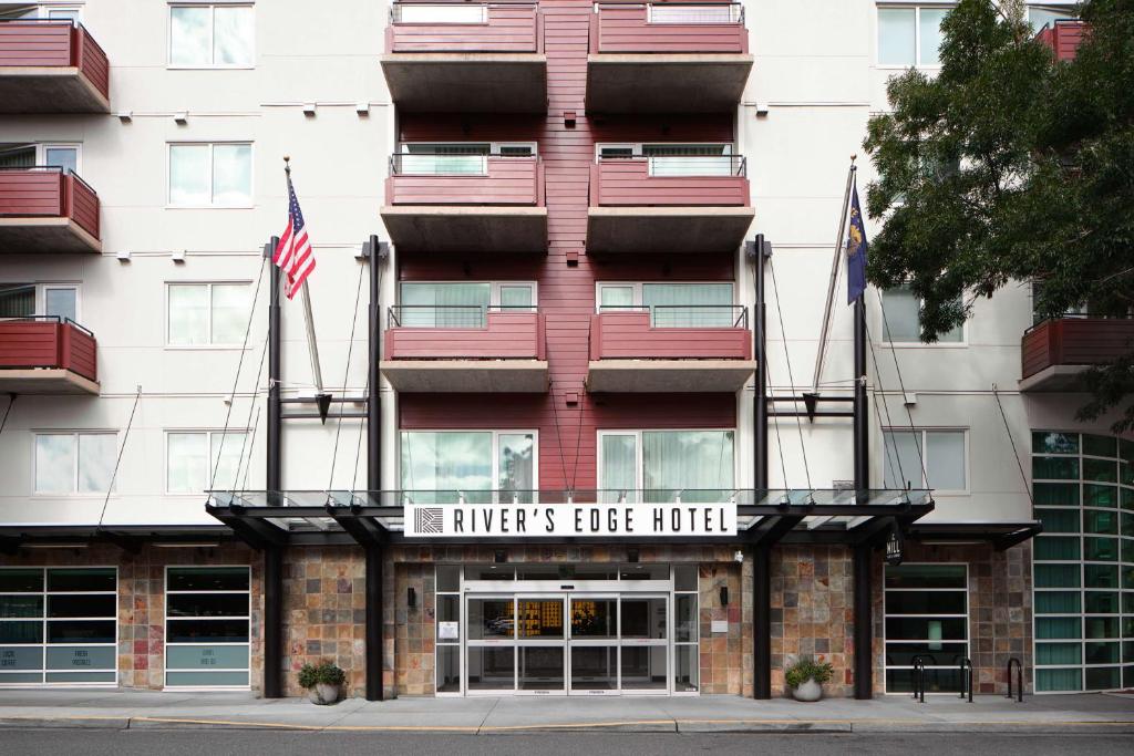 un edificio con dos banderas americanas delante de él en River's Edge Hotel Portland, Tapestry Collection by Hilton, en Portland