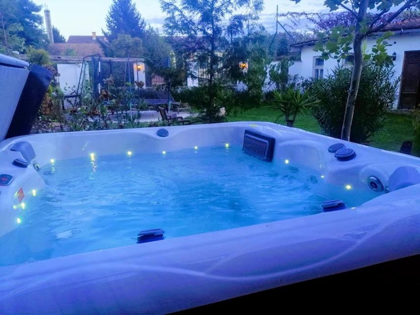 a jacuzzi tub with lights in a backyard at Kúria apartman with private jacuzzi and pool in Budapest