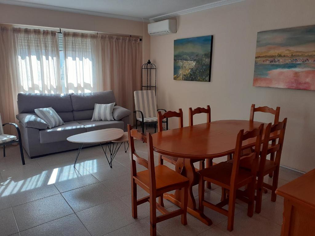 uma sala de estar com uma mesa e um sofá em PAAL PLAYA Solo Familias em Playa de Gandia