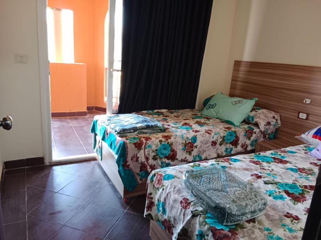 a hotel room with two beds and a window at Porto Matroh New Chalets in Marsa Matruh