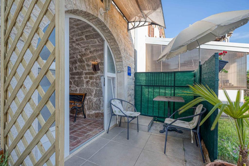 une terrasse avec une table, des chaises et un parasol dans l'établissement Apartment in Porec - Istrien 46934, à Poreč