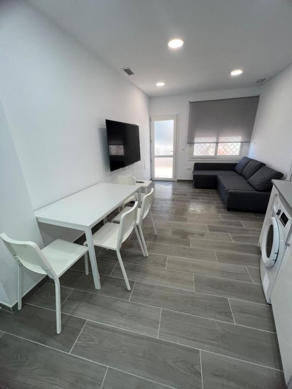 Una sala de estar con una mesa y sillas y un sofá. en Apartamentos BEACHYDAYS Metropolis C, en Torremolinos