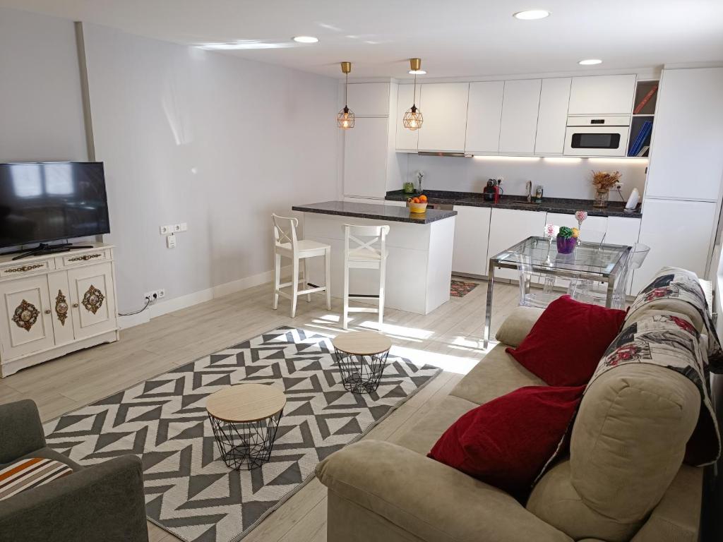ein Wohnzimmer mit einem Sofa und einer Küche in der Unterkunft excelente ubicado y amueblado in León