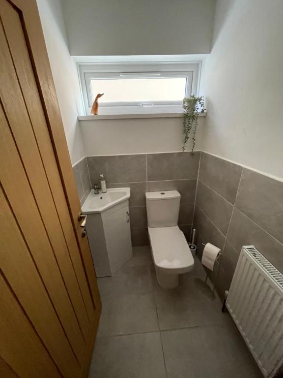 a small bathroom with a toilet and a window at Minster Leas in Sheerness
