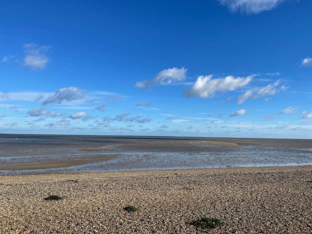 a beach with the ocean and a cloudy sky at Minster Leas in Sheerness