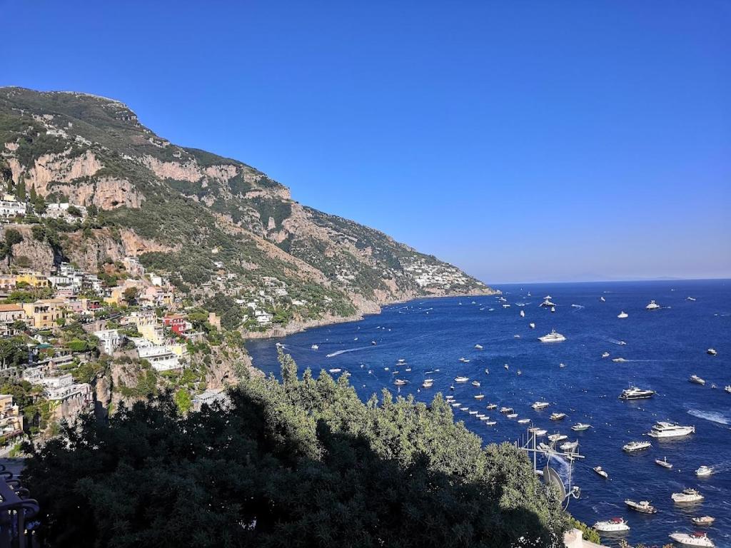 un grupo de barcos en el agua junto a una montaña en Sorrento Holidays - Casa Marcella, en Positano