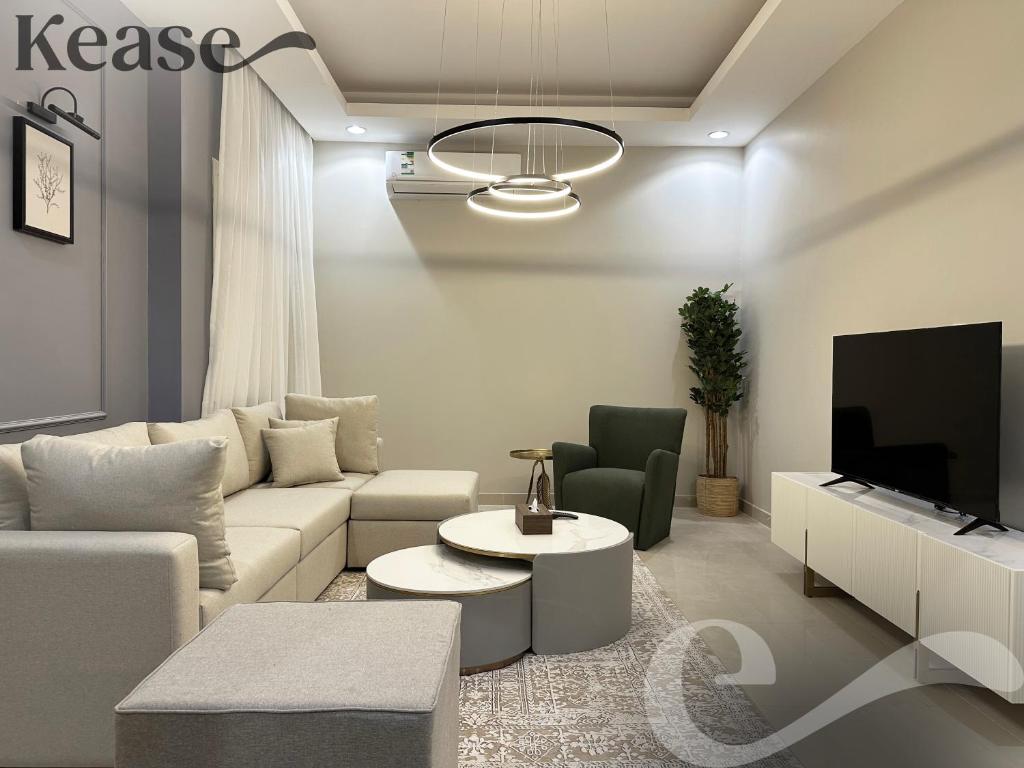 a living room with a couch and a tv at Kease Al-Mutamarat A-10 Timeless History GX66 in Riyadh
