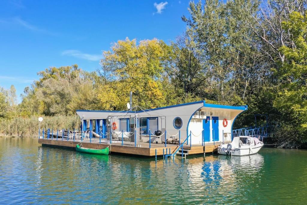 布拉提斯拉瓦的住宿－Očarujúci Houseboat na Dunaji，船屋停靠在水面上