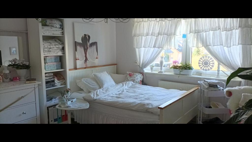 1 dormitorio con cama blanca y ventana en Romantischer Traum, Zimmer mit TV inkl Netflix und Prime, super late check in möglich, en Bielefeld