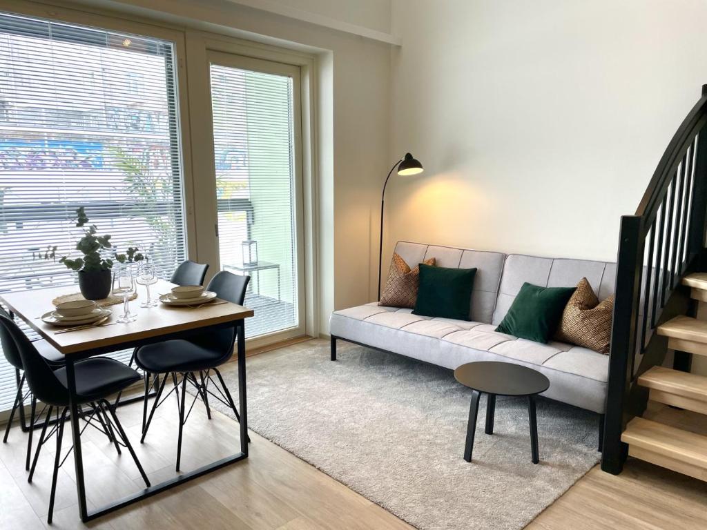 salon z kanapą i stołem w obiekcie Bright loft apartment with glazed balcony w mieście Tampere