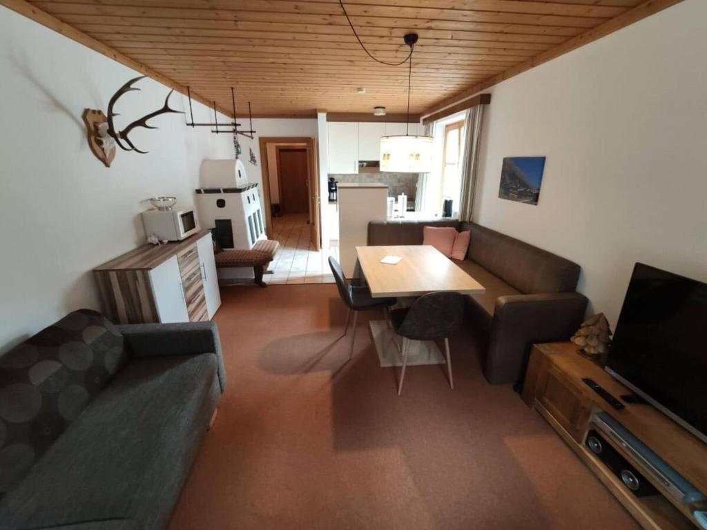 ein Wohnzimmer mit einem Sofa und einem Tisch in der Unterkunft Apartment with mountain view near centre in Maria Alm am Steinernen Meer
