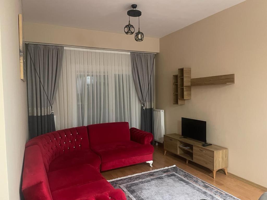 a living room with a red couch and a television at Site merkezi yer in Istanbul