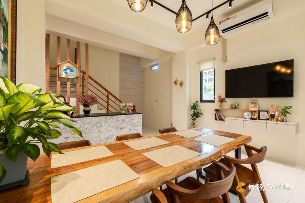 a dining room with a table and a tv at 聚一夏民宿 in Jiali