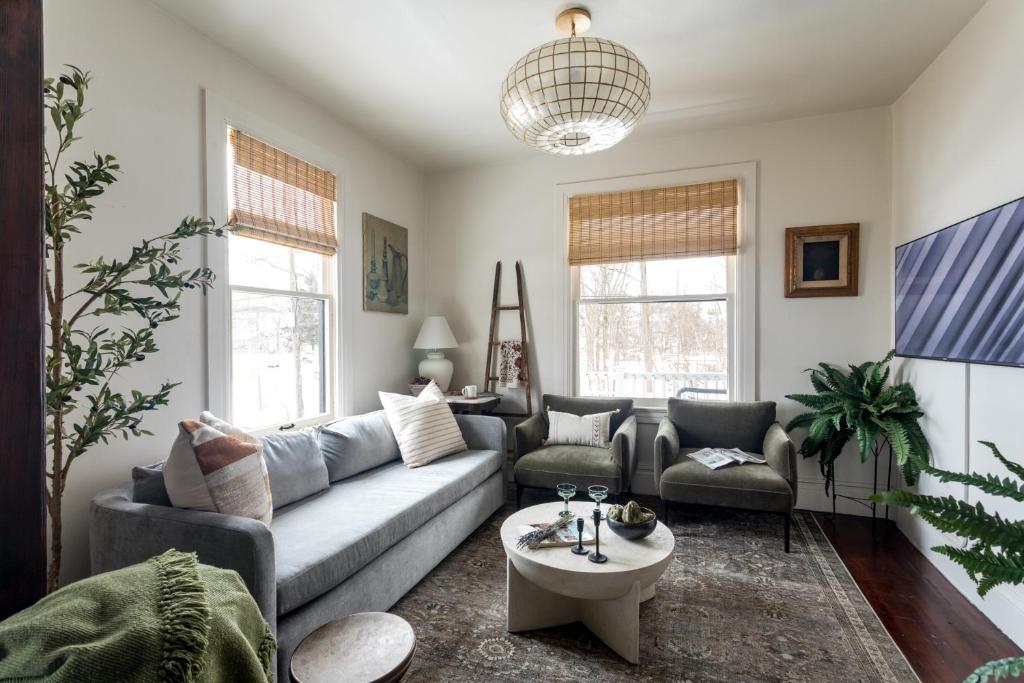 a living room with a couch and a table at Bespoke 1920's Charm, Walk 2 Warren, & Hot Tub - The Spring House in Hudson