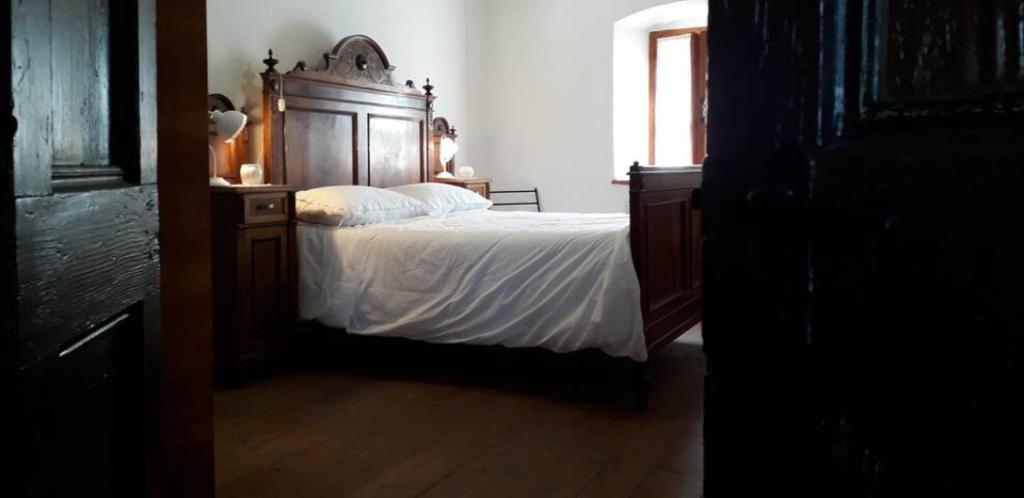 a bedroom with a bed with a wooden headboard at Antica Dimora Russit in Mediis
