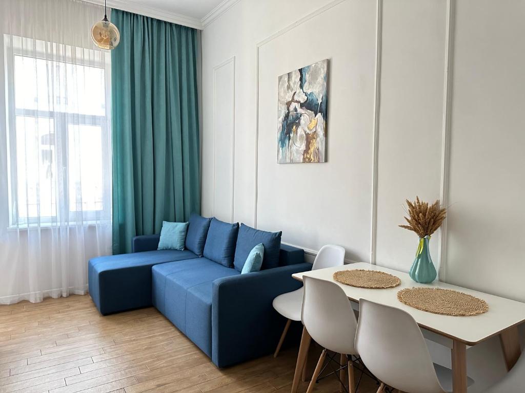 un soggiorno con divano blu e tavolo di Квартира на Огієнка 15 a Lviv