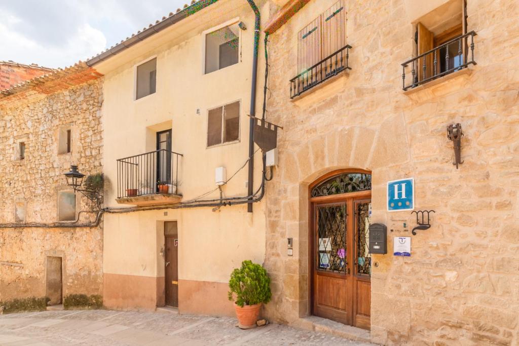 un edificio con una puerta y una planta delante en HOTEL EL CASTELL en Valderrobres