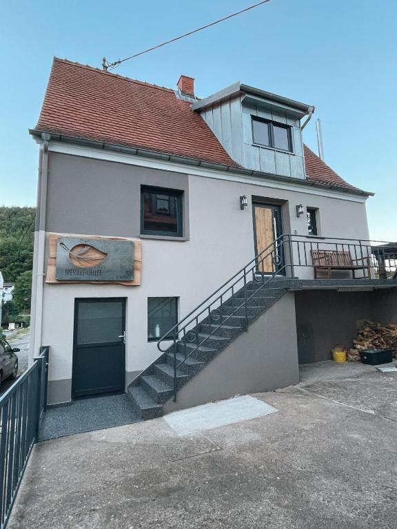 een wit huis met een trap ervoor bij Spessart Chalet in Dammbach