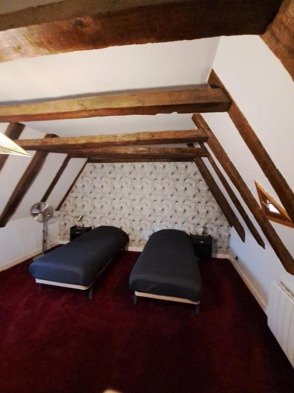 an attic room with two stools on the floor at Maison Domme Dordogne in Domme