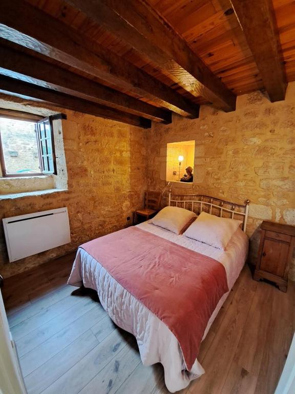 a bedroom with a large bed in a building at Maison Domme Dordogne in Domme