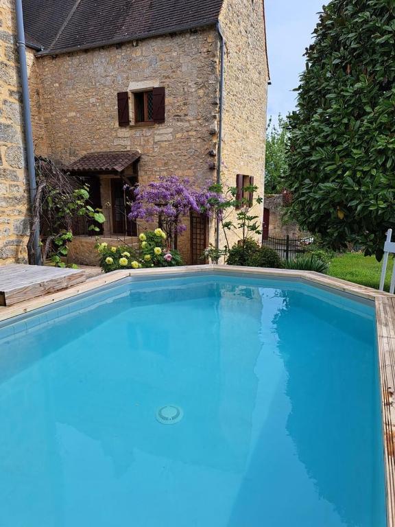 une grande piscine bleue devant une maison dans l'établissement Maison Domme Dordogne, à Domme