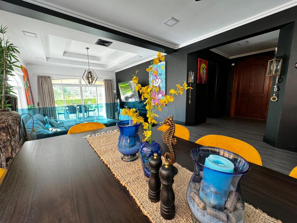 una mesa de comedor con tres jarrones azules. en Luxury Condo at Los Sueños Resort & Marina en La Mona