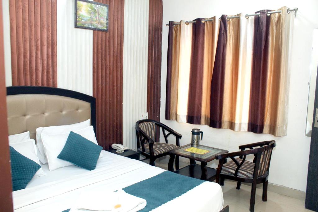 a bedroom with a bed and a table and chairs at Hotel Anand in Haridwār