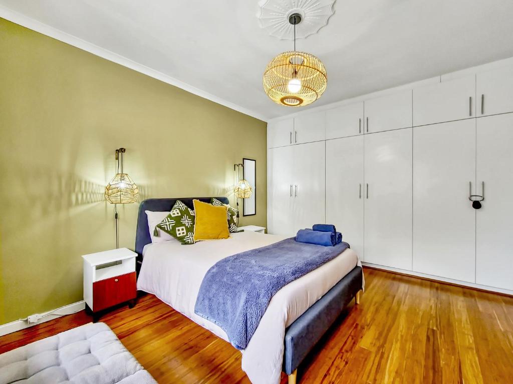 a bedroom with a large bed and white cabinets at Braai, Outdoor dining area, workstation, Fast Wi-Fi in Cape Town
