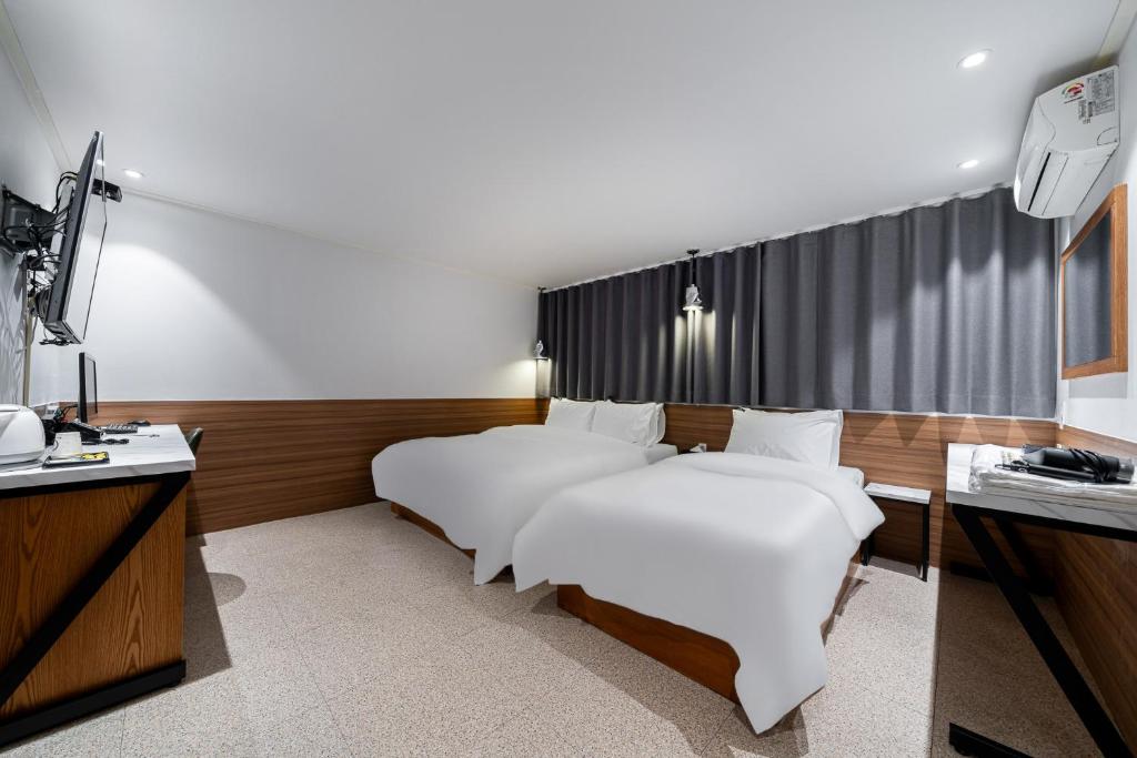 Ένα ή περισσότερα κρεβάτια σε δωμάτιο στο Jamsil Noblestay Hotel