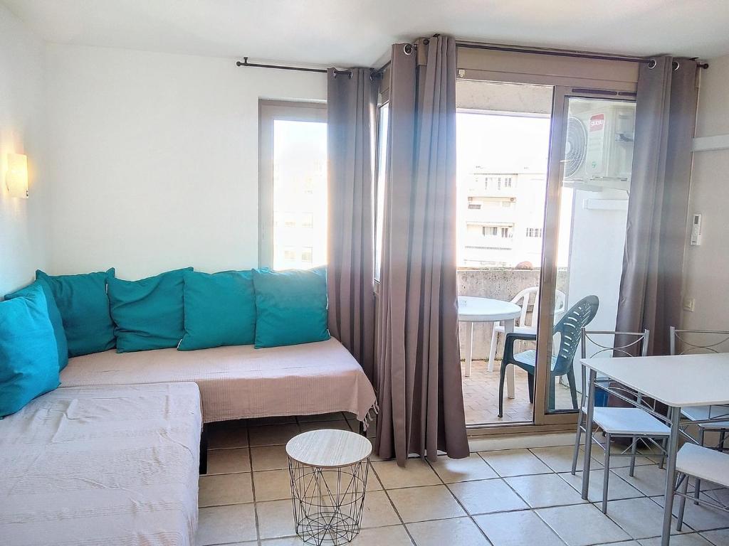 ein Wohnzimmer mit einem Sofa und einem Tisch in der Unterkunft Résidence Graziella Studio 624 in Juan-les-Pins