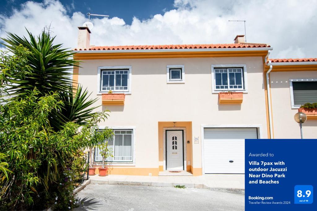 een wit huis met een blauw bord ervoor bij Villa7pax baby friendly Near Dino Park&Beaches in São Bartolomeu