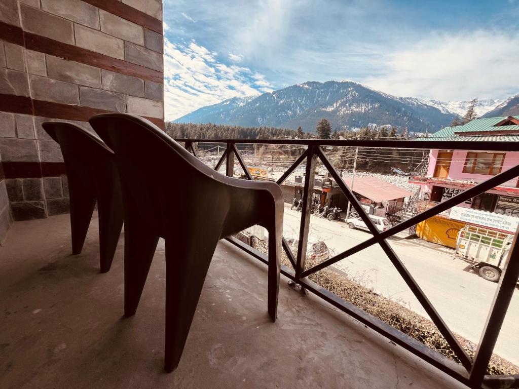 a chair on a balcony with a view of a mountain at Mountain View Resort - A Hidden Resort Manali in Manāli