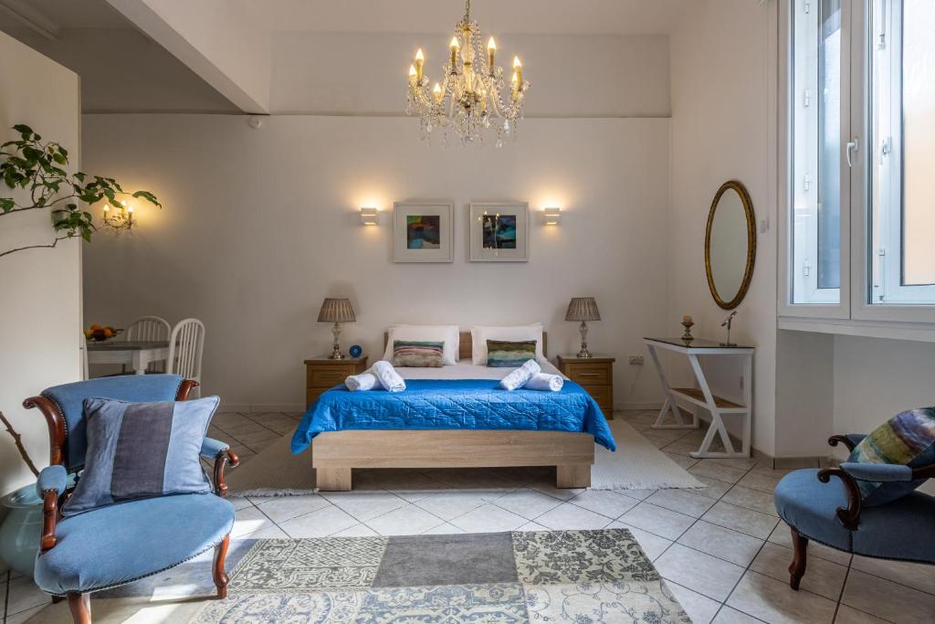 1 dormitorio con 1 cama, 2 sillas y lámpara de araña en Cozy Carisma Lodging - Central, New and Independent Studio Apartment en Sliema