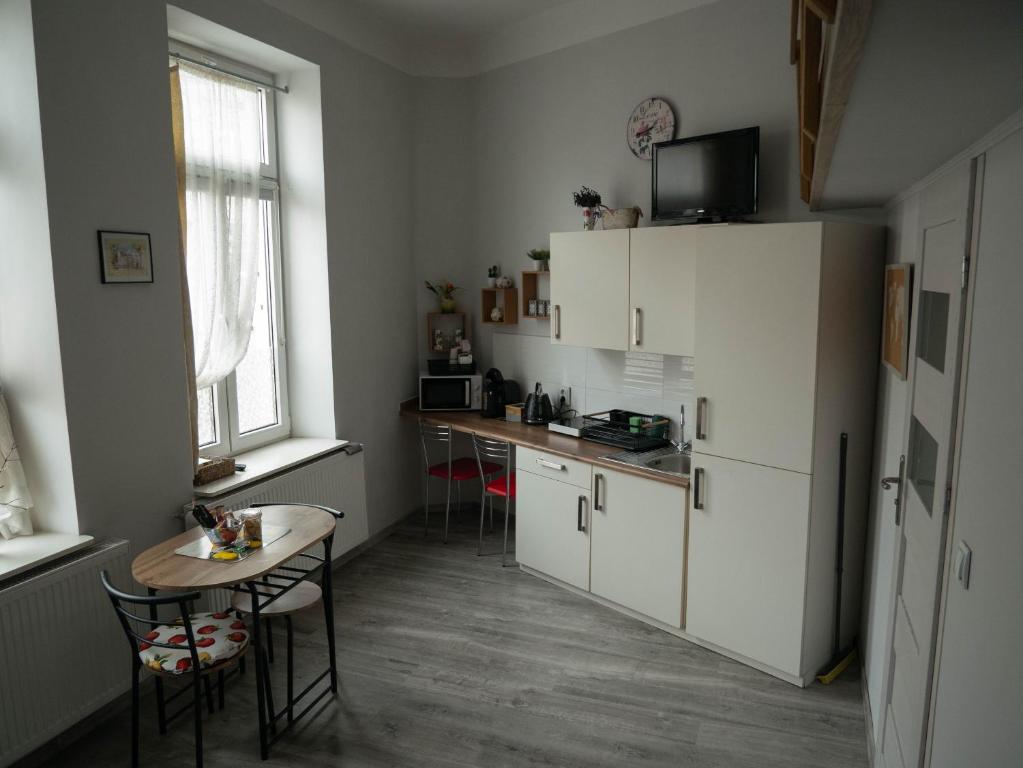 - une cuisine avec une petite table et un comptoir dans l'établissement Apartament przy synagodze, à Przemyśl