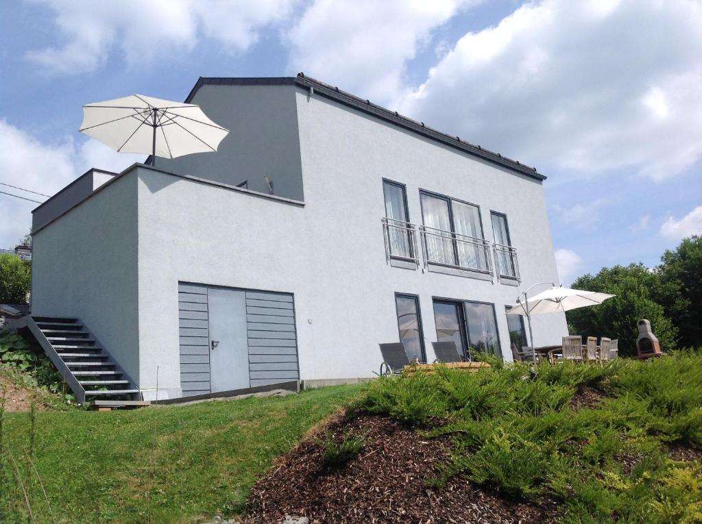 uma casa branca com um guarda-chuva em cima em Moderne woning Malmedy em Malmedy