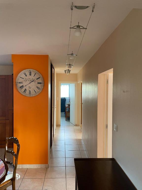 une chambre avec une horloge sur le mur et un couloir dans l'établissement Djimmy hébergement, à Saint-Herblain